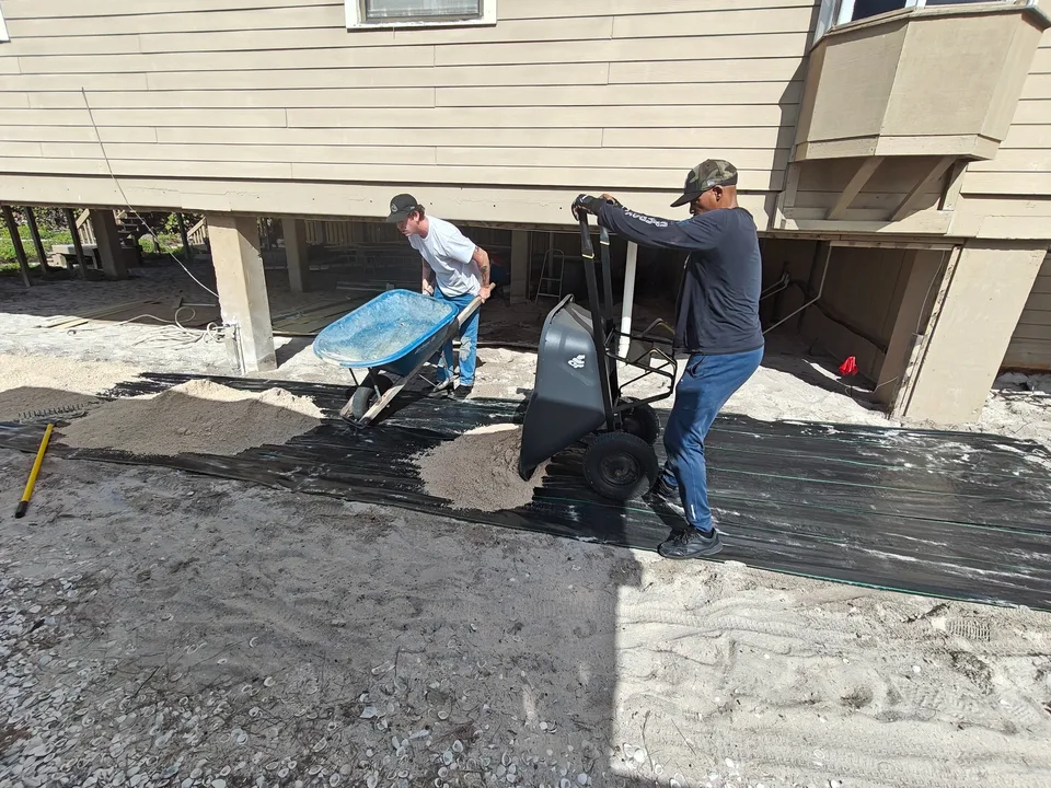 Team loading limestone base material for coastal shell path installation Florida